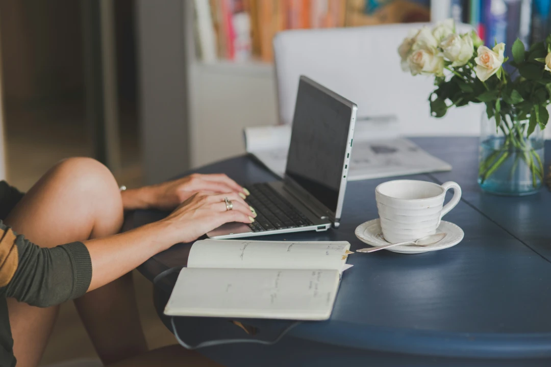 a person sits at a table with a laptop and an open notebook, adding ALT text tags to an image to boost their SEO rankings.